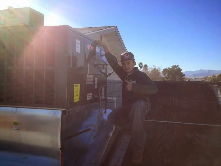 HVAC technician performing AC Tune-Up on a rooftop unit in Pacific Grove